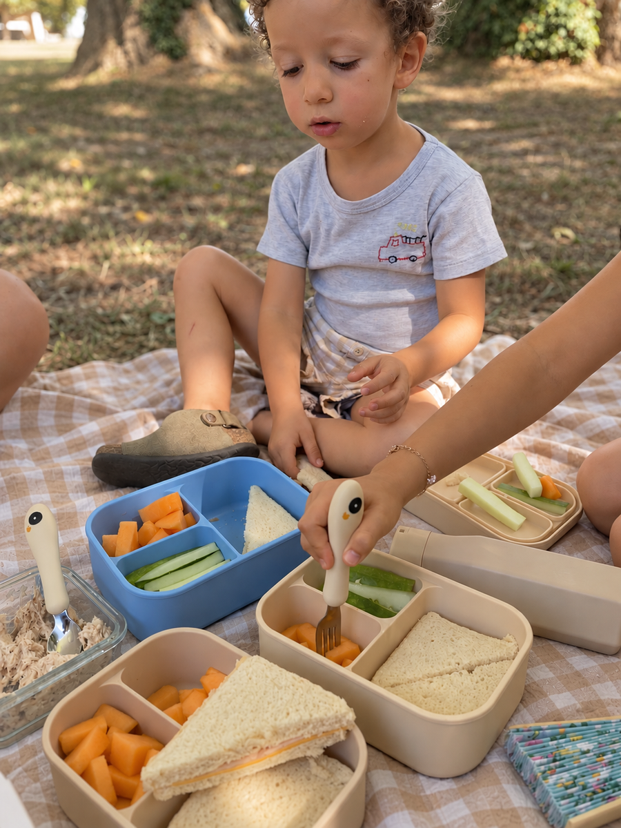 Gourde, lunch box et couverts O'CAOU posés ensemble