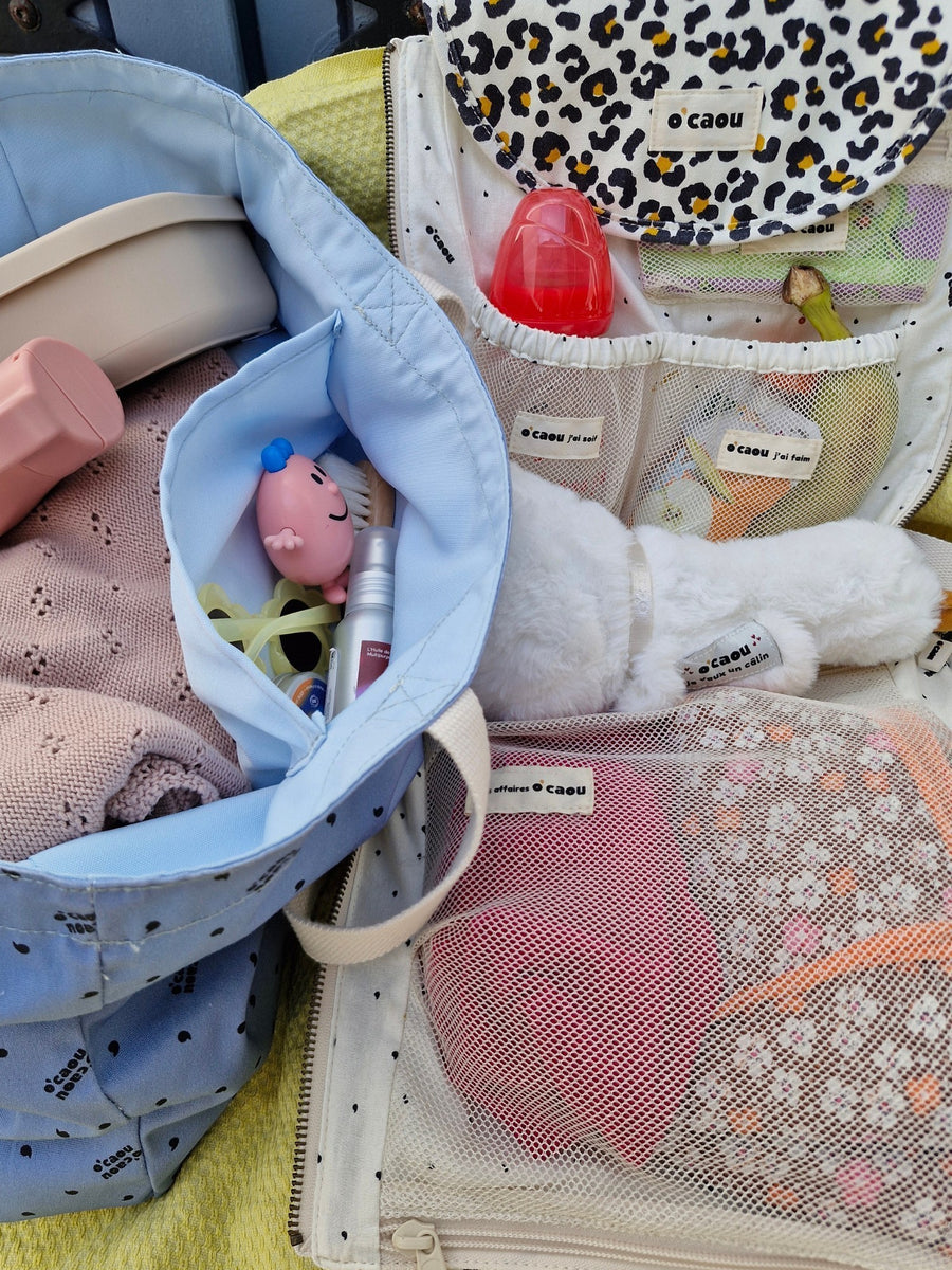 Sac à langer ouvert : affaires de change, biberon et petits jouets rangés