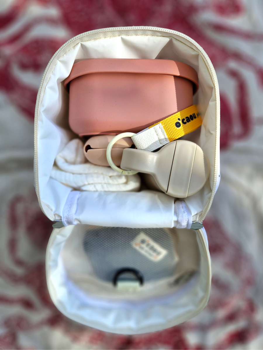 Sac isotherme ouvert : lunch box rose, couverts et gourde rangés à l'intérieur